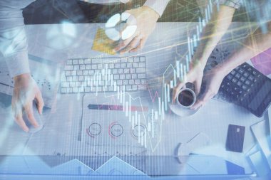 Birlikte çalışan kadın ve erkeğin çifte pozu ve finansal grafik hologramı çizimi. Pazar analizi konsepti. Bilgisayar arkaplanı. Üst Görünüm.