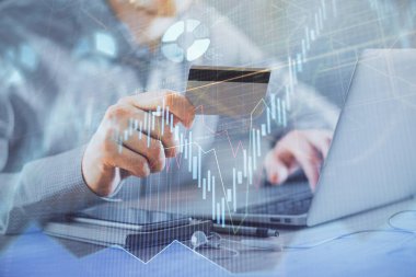 Ellerinde kredi kartı ve forex çizimi olan bir adamın çift pozu. İnternet E-ticaret kavramında hisse senedi ve dijital fintech.