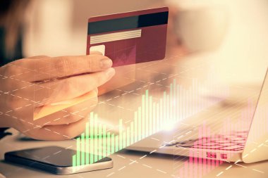 İnternetten alışveriş yapan kadının elinde kredi kartı ve mali grafik çizimi var. Borsa E-ticaret kavramı.