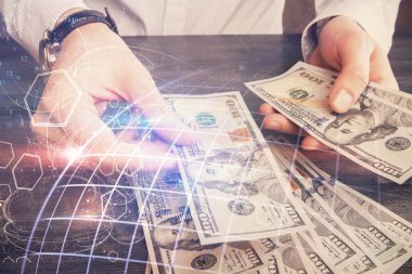 Dünya haritasının iki katına çıkarılması hologram, dolar banknotları ve insan eli..