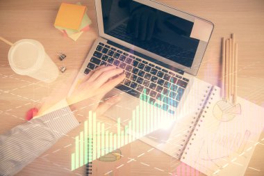 İnsan elinin bilgisayar klavyesinde ve forx grafik hologramının üzerinde yazarken çifte pozlama. Üst Manzara. Finans piyasası kavramı.