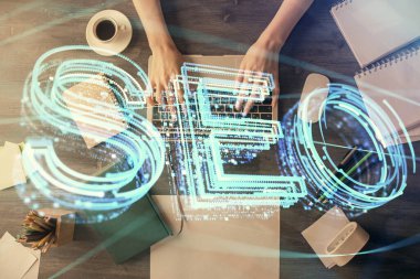 Bilgisayar ve SEO hologram çizimleri üzerinde çalışan kadın elleri çift pozlama. Üst Manzara. Arama optimizasyon kavramı.