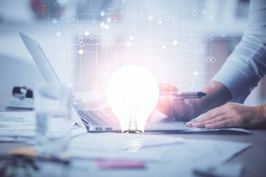 Bilgisayarda yazı yazan ve ampul çizen bir kadının ellerine iki kez maruz kalmış. Fikir kavramı.