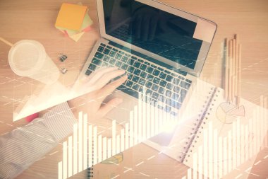 İnsan elinin bilgisayar klavyesinde ve forx grafik hologramının üzerinde yazarken çifte pozlama. Üst Manzara. Finans piyasası kavramı.