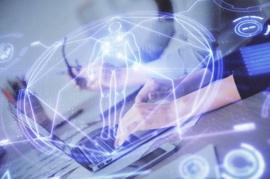 Bilgisayarda yazı yazan kadın elleri ve genel temalı hologram çizimleri. Eğitim kavramı.