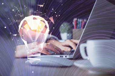 Bilgisayarda yazı yazan ve ampul çizen bir kadının ellerine iki kez maruz kalmış. Fikir kavramı.