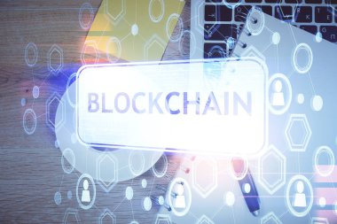 Masaüstü arkaplanındaki bilgisayarın üzerinden engelleme temalı hologram çizimleri. Üst Manzara. Çoklu maruz kalma. Kripto ekonomi kavramı.