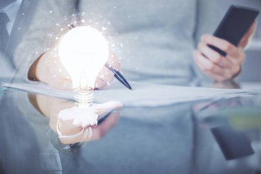 Ampul hologramına çift pozlama ve mobil cihaz kullanan bir kadın. Fikir kavramı.