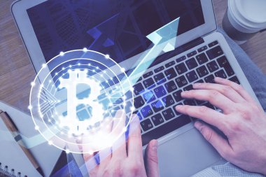 Bilgisayar klavyesinin ve şifreli para birimi temalı hologram çiziminin üzerine iki kez yazılan el pozu. Üst Manzara. Engelleme zinciri kavramı.