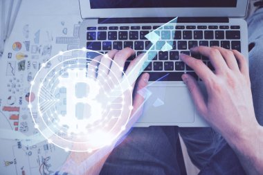 Bilgisayar klavyesinin ve şifreli para birimi temalı hologram çiziminin üzerine iki kez yazılan el pozu. Üst Manzara. Engelleme zinciri kavramı.