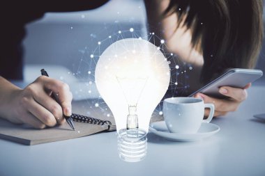 Ampul hologramına çift pozlama ve mobil cihaz kullanan bir kadın. Fikir kavramı.