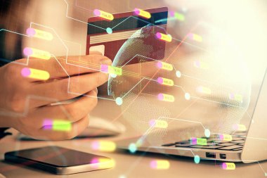 Elinde kredi kartı ve dünya haritası çizimi olan bir kadının online alışverişine iki kez maruz kalışı. Uluslararası E-ticaret kavramı.