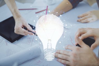 Ampul hologramı ve kadın ve erkeğin birlikte çalışıp mobil bir cihaz kullanması. Fikir kavramı