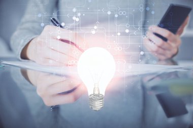 Ampul hologramına çift pozlama ve mobil cihaz kullanan bir kadın. Fikir kavramı.