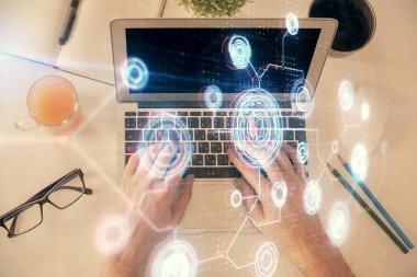 İnsan elinin bilgisayar klavyesi ve veri temalı hologram çiziminin üzerine yazarken çoklu pozlama. Üst Manzara. Teknoloji konsepti.