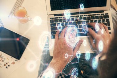 İnsan elinin bilgisayar klavyesi ve veri temalı hologram çiziminin üzerine yazarken çoklu pozlama. Üst Manzara. Teknoloji konsepti.