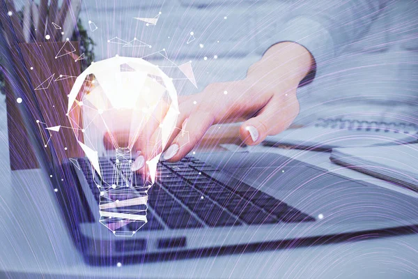 Bilgisayarda yazı yazan ve ampul çizen bir kadının ellerine iki kez maruz kalmış. Fikir kavramı.