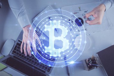 Bilgisayar klavyesinin ve şifreli para birimi temalı hologram çiziminin üzerine iki kez yazılan el pozu. Üst Manzara. Engelleme zinciri kavramı.