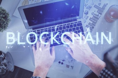 Bilgisayar klavyesinin ve şifreli para birimi temalı hologram çiziminin üzerine iki kez yazılan el pozu. Üst Manzara. Engelleme zinciri kavramı.