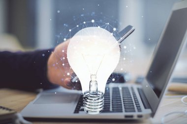 Dijital bir cihaz ve ampul hologram çizimi kullanarak insanın ellerini tutarken çift pozlama. Fikir kavramı.