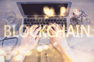 Bilgisayar klavyesinin ve şifreli para birimi temalı hologram çiziminin üzerine iki kez yazılan el pozu. Üst Manzara. Engelleme zinciri kavramı.