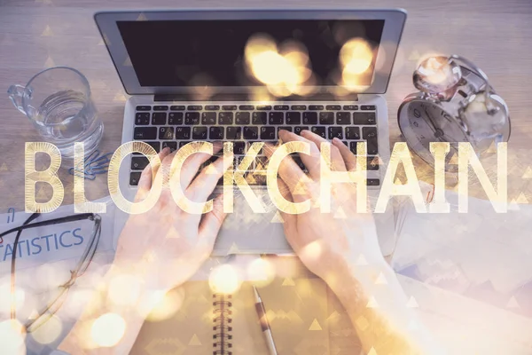 Bilgisayar klavyesinin ve şifreli para birimi temalı hologram çiziminin üzerine iki kez yazılan el pozu. Üst Manzara. Engelleme zinciri kavramı.