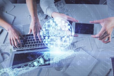 Kadın ve erkeğin birlikte çalışırken çift pozlama ve şifreli hologram çizimi. Bilgisayar arkaplanı. Blockchain konsepti. Üst Görünüm.