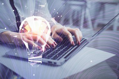 Bilgisayarda yazı yazan ve ampul çizen bir kadının ellerine iki kez maruz kalmış. Fikir kavramı.