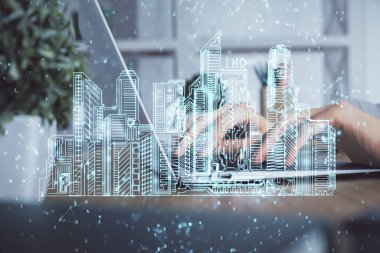 Bilgisayarda yazı yazan kadın elleri ve çizim yapan binalar. Akıllı şehir konsepti.