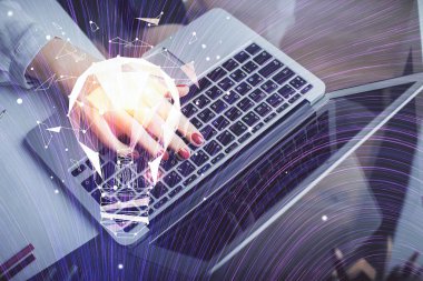 Bilgisayarda yazı yazan ve ampul çizen bir kadının ellerine iki kez maruz kalmış. Fikir kavramı.