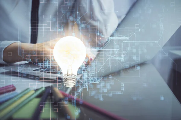 Bilgisayarda yazı yazan ve ampul çizen bir kadının ellerine iki kez maruz kalmış. Fikir kavramı.