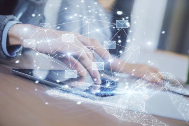 Double exposure of envelop theme hologram and man and woman working together holding and using a mobile device.
