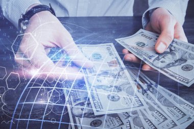 Dünya haritasının iki katına çıkarılması hologram, dolar banknotları ve insan eli..