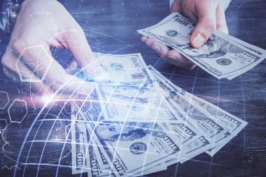 Dünya haritasının iki katına çıkarılması hologram, dolar banknotları ve insan eli..