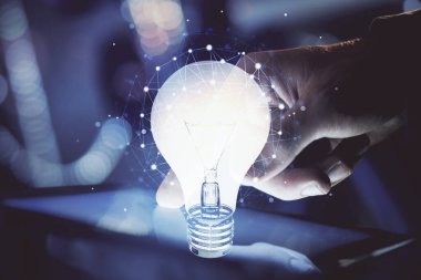 Dijital bir cihaz ve ampul hologram çizimi kullanarak insanın ellerini tutarken çift pozlama. Fikir kavramı.