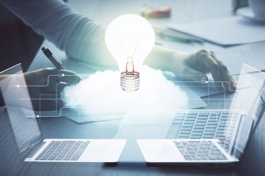 Bilgisayarda yazı yazan ve ampul çizen bir kadının ellerine iki kez maruz kalmış. Fikir kavramı.