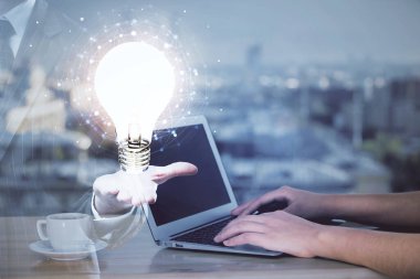 Bilgisayarda yazı yazan ve ampul çizen bir kadının ellerine iki kez maruz kalmış. Fikir kavramı.