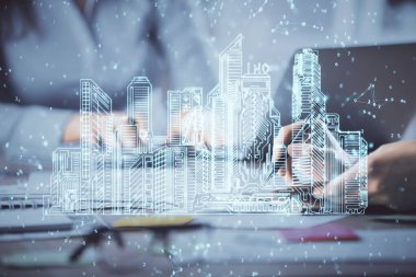 Bilgisayarda yazı yazan kadın elleri ve çizim yapan binalar. Akıllı şehir konsepti.