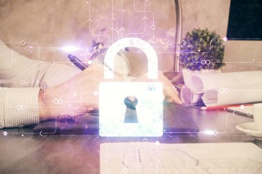 Dijital bir cihaz ve kilit çizimi kullanan bir adamın el ele tutuşması. Güvenlik kavramı.