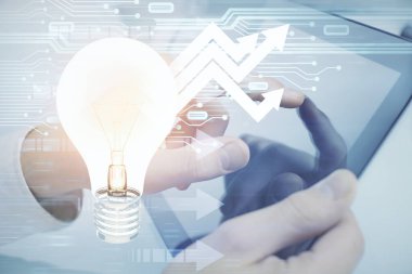 Dijital bir cihaz ve ampul hologram çizimi kullanarak insanın ellerini tutarken çift pozlama. Fikir kavramı.