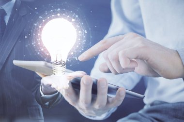 Dijital bir cihaz ve ampul hologram çizimi kullanarak insanın ellerini tutarken çift pozlama. Fikir kavramı.