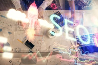 SEO hologram çizimleri ve birlikte çalışan kadın ve erkeğin çifte pozu. Arama motoru konsepti. Bilgisayar arkaplanı. Üst Görünüm.