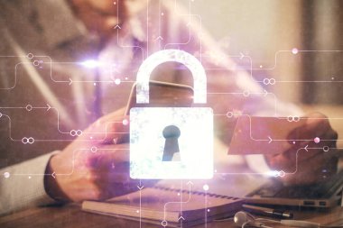 Dijital bir cihaz ve kilit çizimi kullanan bir adamın el ele tutuşması. Güvenlik kavramı.