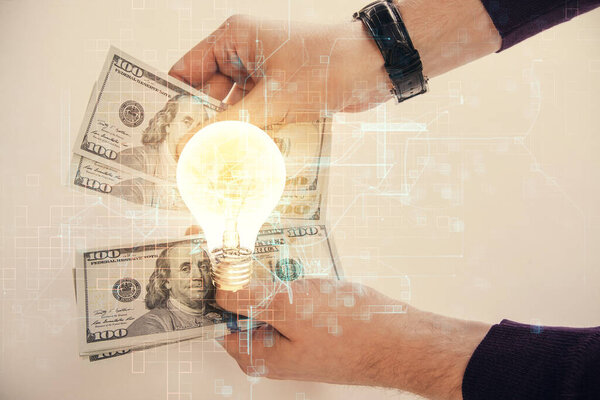 Multi exposure of bulb drawing hologram and USA dollars bills and man hands. Business Idea concept.