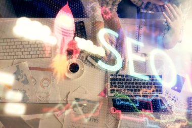 SEO hologram çizimleri ve birlikte çalışan kadın ve erkeğin çifte pozu. Arama motoru konsepti. Bilgisayar arkaplanı. Üst Görünüm.