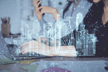 Bilgisayarda yazı yazan kadın elleri ve çizim yapan binalar. Akıllı şehir konsepti.