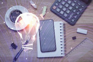 Ampulü telefonla masanın üzerine çizerken çift pozlama. Üst Manzara. Fikir kavramı.