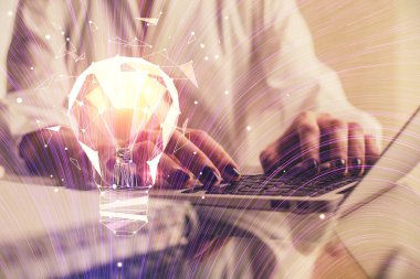 Bilgisayarda yazı yazan ve ampul çizen bir kadının ellerine iki kez maruz kalmış. Fikir kavramı.