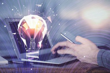 Dijital bir cihaz ve ampul hologram çizimi kullanarak insanın ellerini tutarken çift pozlama. Fikir kavramı.