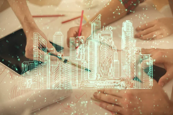 Double exposure of town hologram and man and woman working together holding and using a mobile device. Smart city concept.